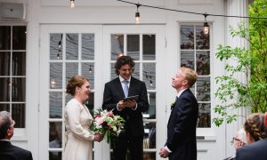 A bride and groom saying their vows on the patio. Photo Credit: Novella Photography