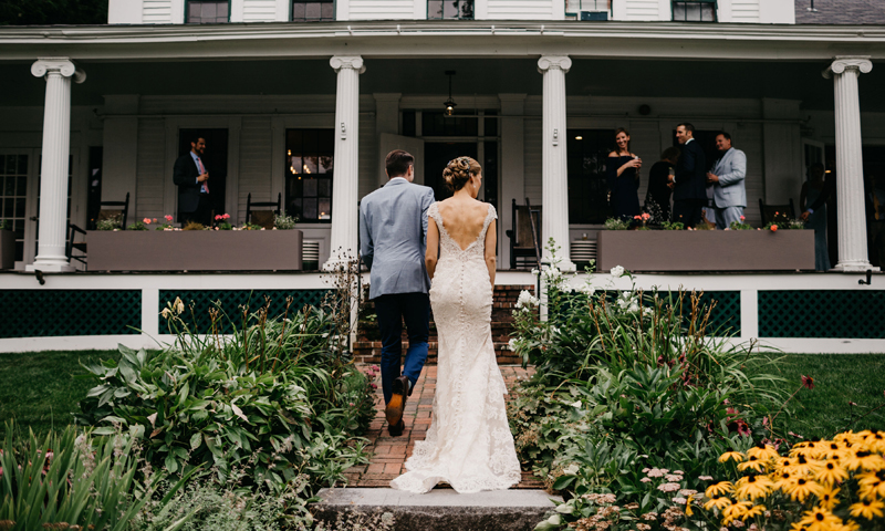 A bride and groom walking up the front staircase at Whitehall. Photo Credit: Lindsay Vann Photography