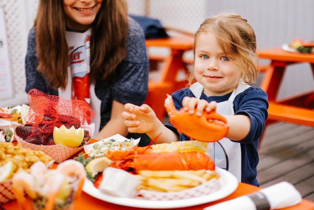 Kid with lobster claw. Photo Credit: Jamie Mercurio Photography