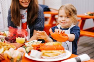 Kid with lobster claw. Photo Credit: Jamie Mercurio Photography