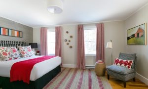 Guest room with a bed and seating area. Photo Credit: Rarebrick Photography