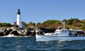 Boat passing Portland Head Light. Photo Provided by Maine Day Ventures