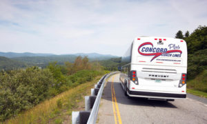 Bus on road with mountains in view. Photo Provided by Concord Coach Lines Bus on road with mountains in view. Photo Provided by Concord Coach Lines