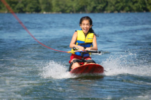 Girl being pulled by boat while kneeboarding