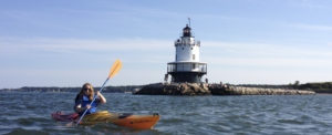 paddling out in kayak in front of Spring Point Ledge Lighthouse Maine