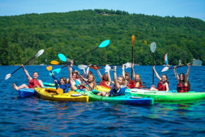 Maine Summer Camps group kayaking with mountains in the background
