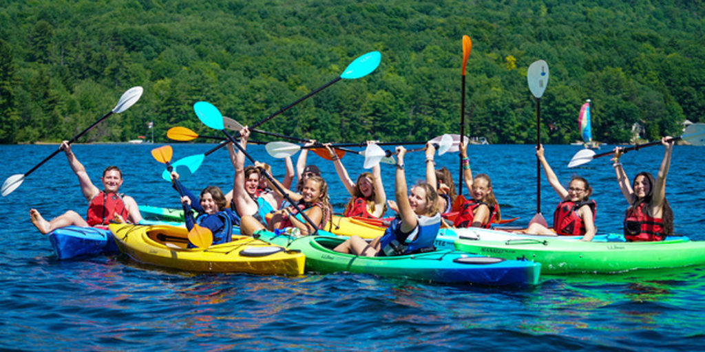 Maine Summer Camps group kayaking with mountains in the background