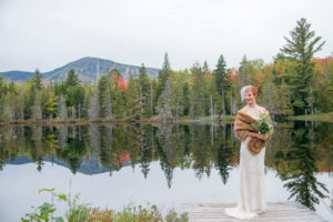 Bride on Dock by Water. Photo Credit: Garrick Dixon