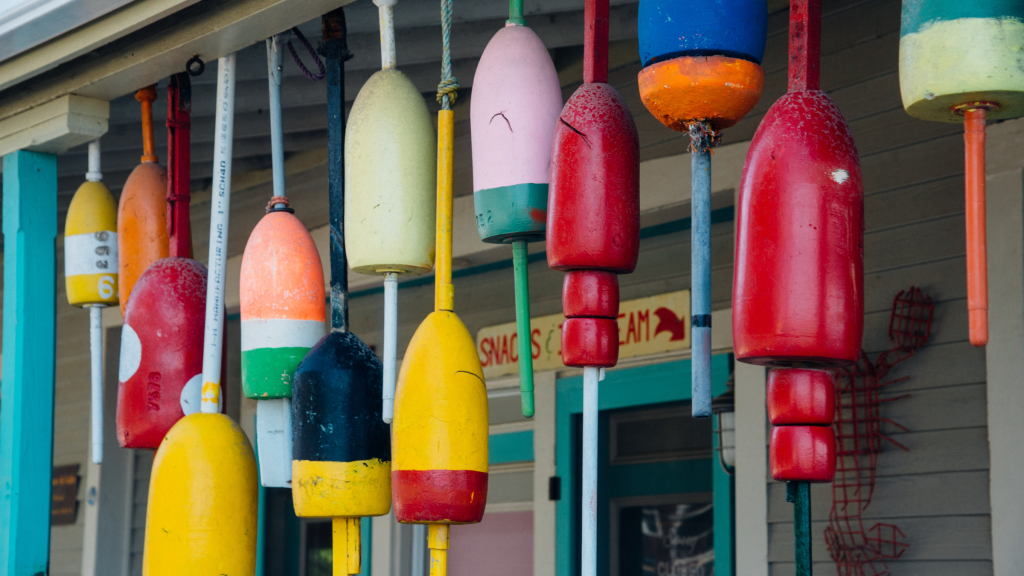 A collection of colorful fishing buoys hanging in front of a building in Portland Maine.