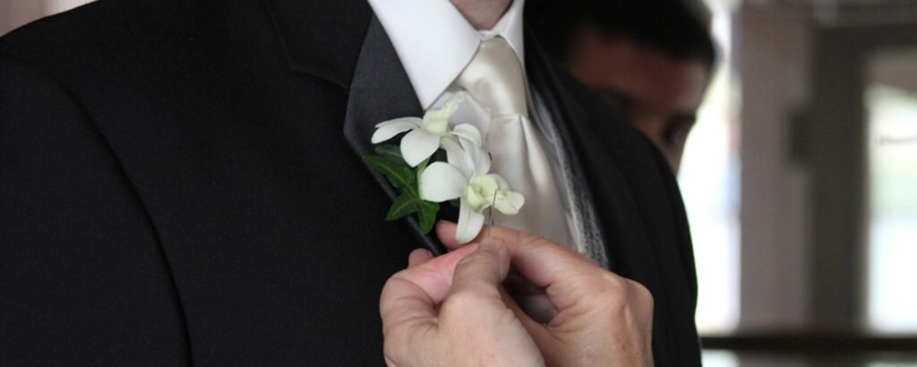 Groom Getting White Boutonniere Pinned On, Photo Credit: Focus Photography