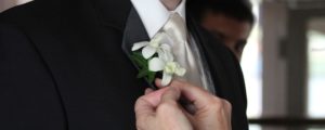 Groom Getting White Boutonniere Pinned On, Photo Credit: Focus Photography