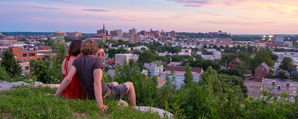 Couple sitting on hill over city, Photo Credit: Corey Templeton