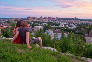 Couple sitting on hill over city, Photo Credit: Corey Templeton