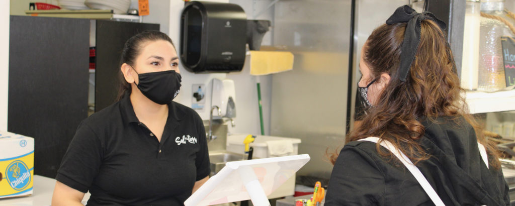 Customer and server in masks at Sal De La Tierra, Photo Courtesy Adam MacDonald Customer and server in masks at Sal De La Tierra, Photo Courtesy Adam MacDonald