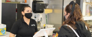 Customer and server in masks at Sal De La Tierra, Photo Courtesy Adam MacDonald