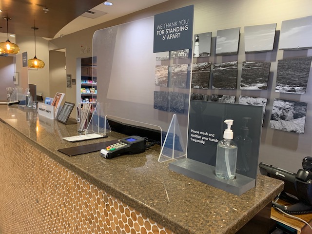 Front desk with protective barrier and sanitizer, Photo Credit: Residence Inn Portland Downtown Waterfront