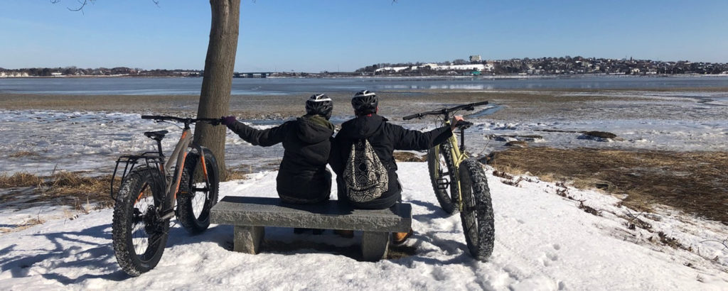 Couple Looking Out at Casco Bay with Fat Bikes in Winter, Photo Provided by Summer Feet Cycling