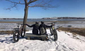 Couple Looking Out at Casco Bay with Fat Bikes in Winter, Photo Provided by Summer Feet Cycling
