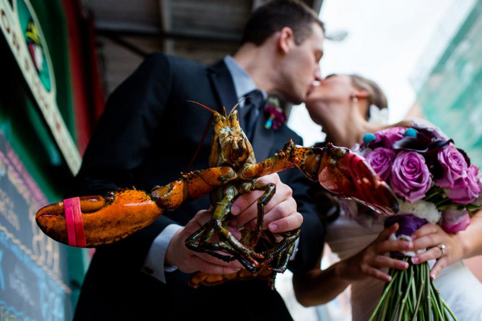Couple Kissing Holding Lobster. Photo Credit: Emilie Inc