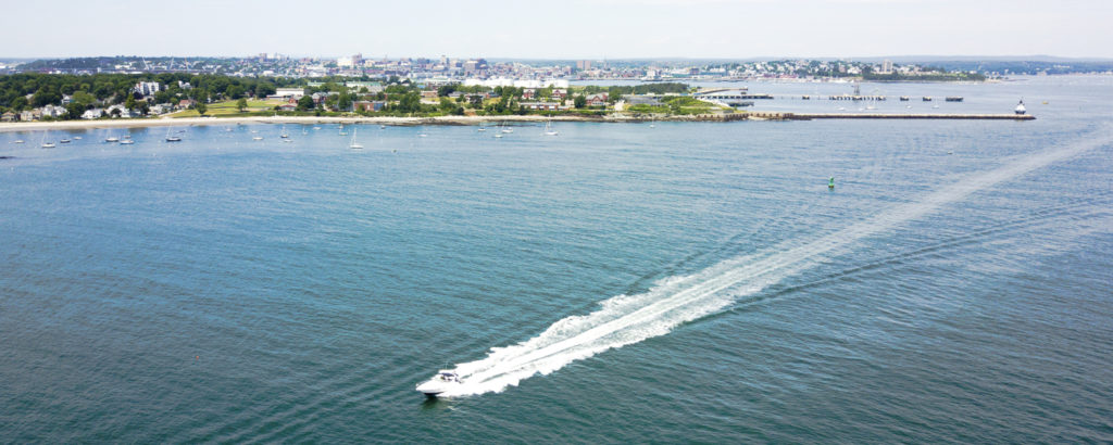 Boat on Casco Bay with City - Photo Credit Capshore Photography Boat on Casco Bay with City - Photo Credit Capshore Photography