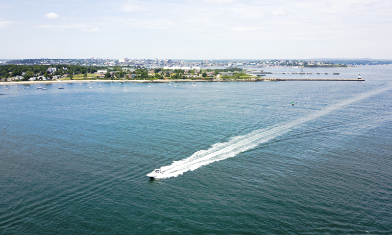 Boat on Casco Bay with City - Photo Credit Capshore Photography