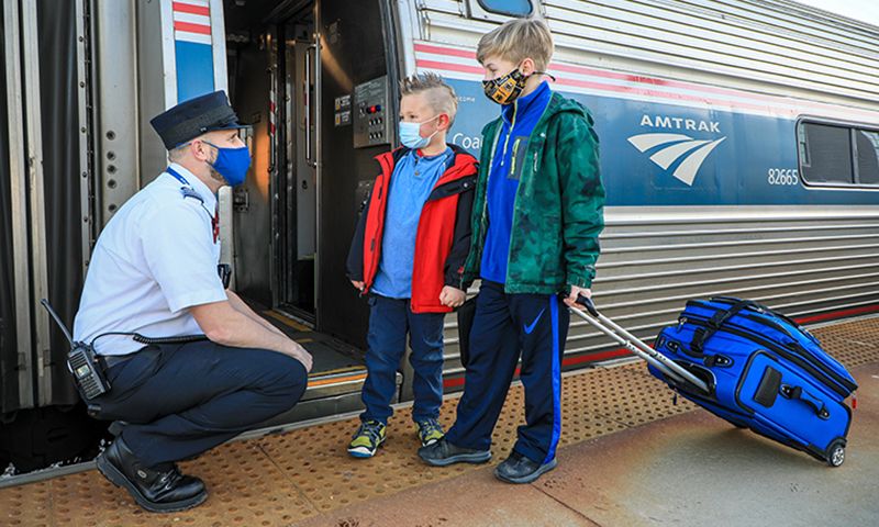 Kids and Conductor Boarding Amtrak Downeaster. Photo Courtesy of NNEPRA