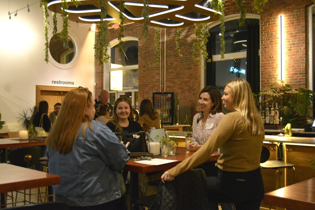 People sitting at a table and talking at the VP Partner Mixer. Photo credit: Harleigh Gastman