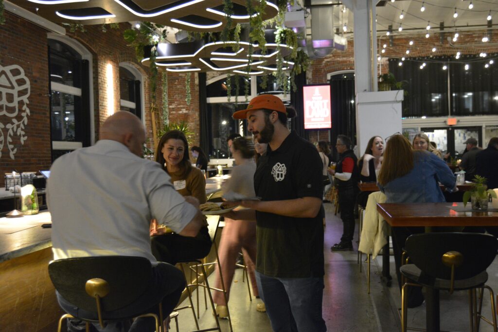 People sitting at a table and talking at the VP Partner Mixer. Photo credit: Harleigh Gastman