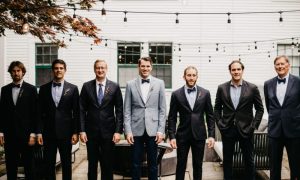 A groom and his groomsmen posing for a picture on the patio. Photo Credit: Lindsay Vann Photography