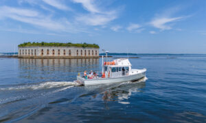 Boat Cruising Past Fort Gorges. Photo Credit: PGM Photography