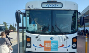 People boarding a white city loop shuttle bus; Photo Credit: Richard Leeman