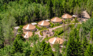 Aerial of yurt community surrounded by green woods; Photo Credit: Peter G. Morneau Photography