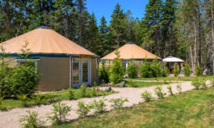 Community of outdoor yurt suites on gravel path ; Photo Credit: Peter G. Morneau Photography