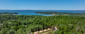 Aerial of green forest and blue ocean in Acadia; Photo Credit: Peter G. Morneau Photography