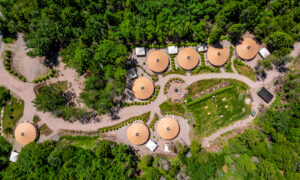 Aerial of yurt community surrounded by green woods; Photo Credit: Peter G. Morneau Photography