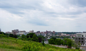 Portland city skyline from grassy hill on cloudy day; Photo Credit: Lauren Peters at Visit Portland