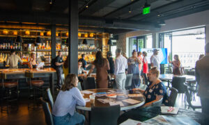 Group of people socializing at restaurant and bar; Photo Credit: Lauren Peters at Visit Portland