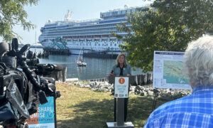Woman giving press conference in front of a docked cruise ship; Photo Credit: Angie Helton
