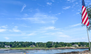 Beachgoers on sunny day with American Flag; Photo Credit: Lauren Peters at Visit Portland