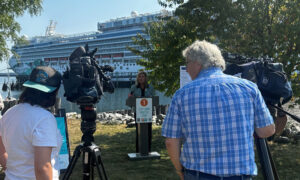 Woman giving press conference in front of a docked cruise ship; Photo Credit: Angie Helton