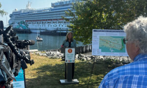 Woman giving press conference in front of a docked cruise ship; Photo Credit: Angie Helton