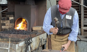 Man hammering iron; Photo Credit: Maine Maritime Museum