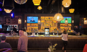 Woman standing at bar; Photo Credit: Lauren Peters at Visit Portland