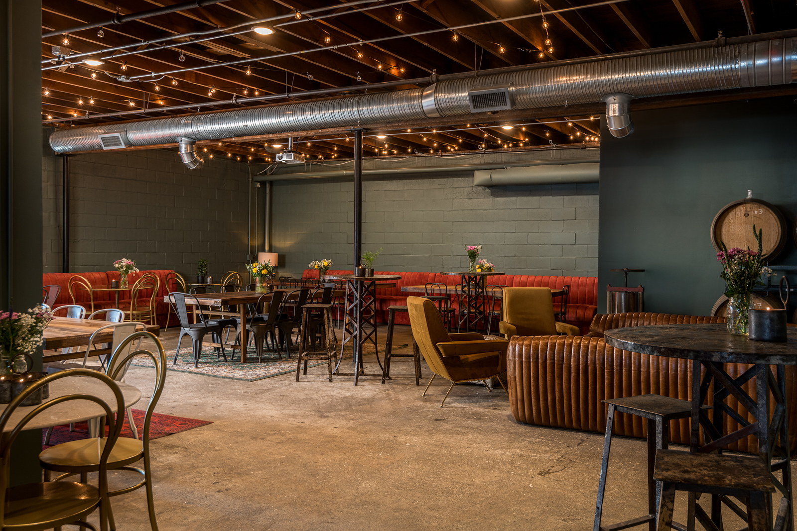 An industrial-style lounge with exposed ceiling, brick walls, and comfortable seating arrangements in Portland Maine.