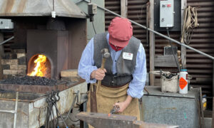 Man hammering iron; Photo Credit: Maine Maritime Museum