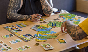 People playing a board game; Photo Credit: Amanda Huebner Photography