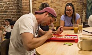 Man concentrating on Operation Game; Photo Credit: Amanda Huebner Photography