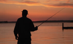 Person fishing at sunset; Photo Credit: Digital Edge