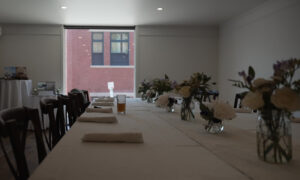 Long white table set for eating; Photo Credit: Digital Edge