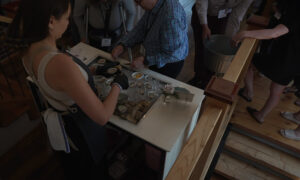 Woman shucking oysters; Photo Credit: Digital Edge